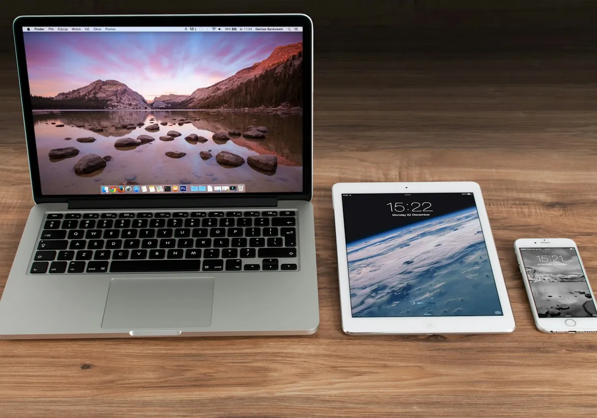 Ahşap masa üzerinde dizüstü bilgisayar, tablet ve akıllı telefon